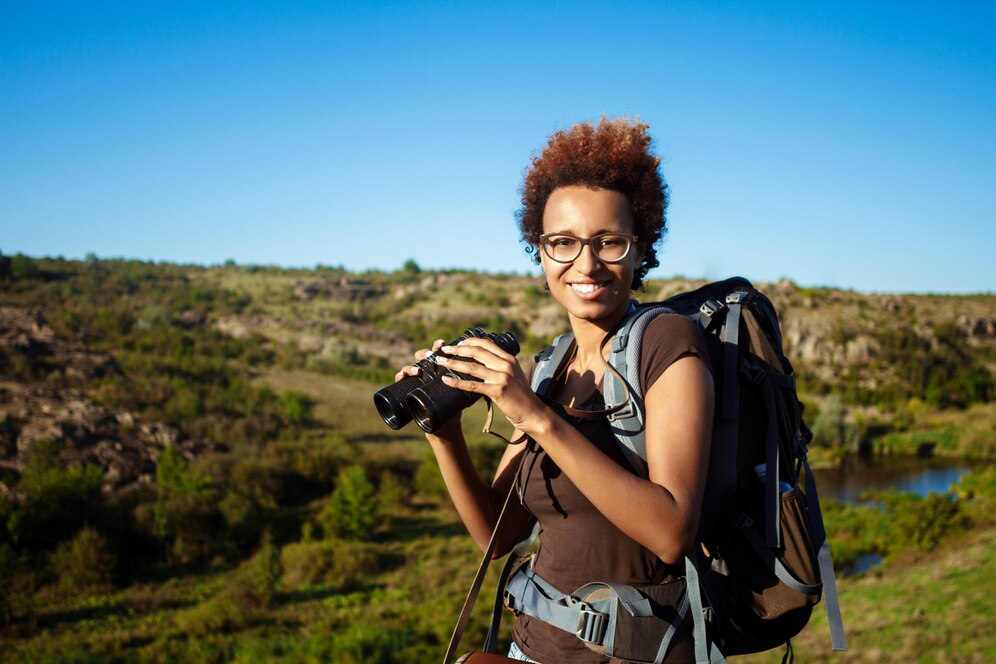 beautiful woman with backpack smiling holding binoculars 176420 4266